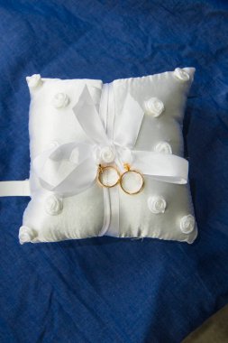 Beyaz ve yumuşak bir yastıktaki alyanslar güzel ve güzel kokulu çiçeklerle, aşkın sembolü sonsuza dek 