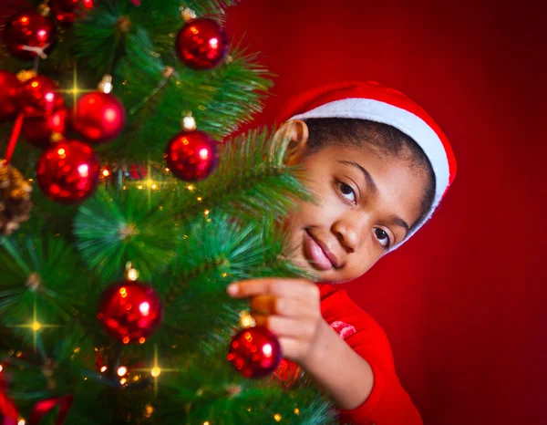 黒い少女はクリスマス ツリーを飾る ロイヤリティフリーのストック写真
