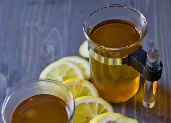 Té, limón y un cuchillo en madera —  Fotos de Stock