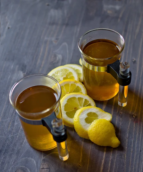 Chá, limão e uma faca na madeira — Fotografia de Stock