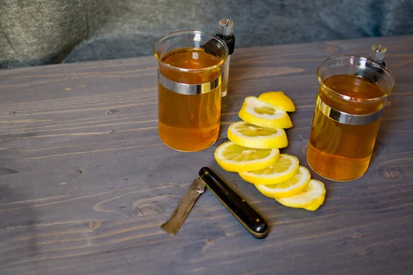 Tè, limone e un coltello su tavola — Foto Stock