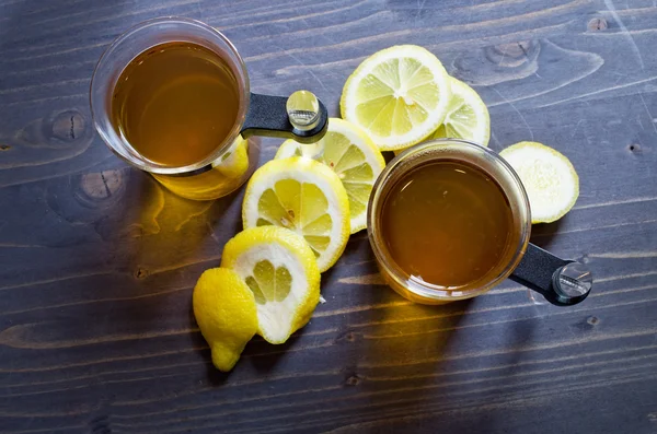 Té, limón y un cuchillo en madera —  Fotos de Stock