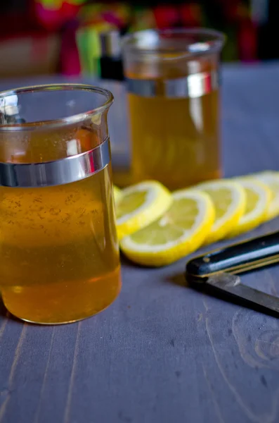 Té, limón y un cuchillo en madera —  Fotos de Stock