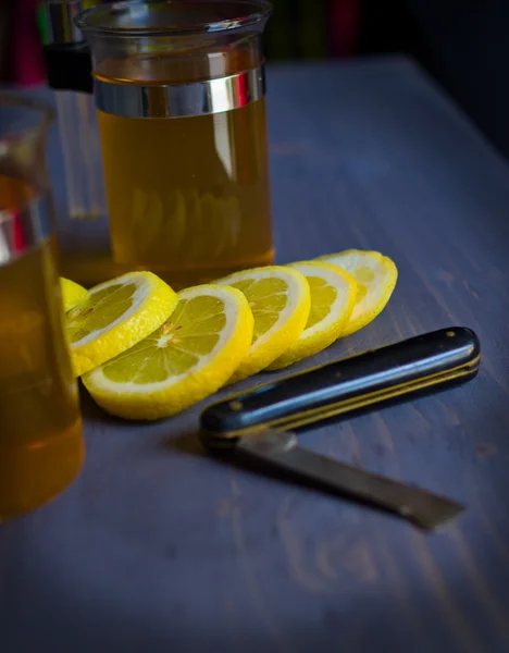 Te, citron och en kniv på woodboard — Stockfoto