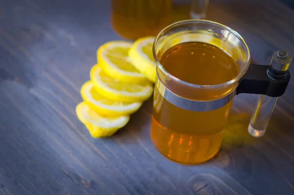 Té, limón y un cuchillo en madera —  Fotos de Stock