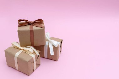 Pembe arka planda kurdeleli paketlenmiş hediyeler. Sürpriz konsept, kopyalama alanı 
