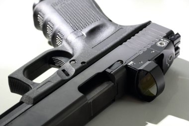 Beyaz arka planda 9 mm 'lik bir tabancanın yakın çekimi. Kırmızı nokta görüşlü bir tabanca. Glock 19.