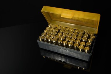 Karanlık bir arka planda 9 mm 'lik bir cephanenin olduğu kutuya yakın çekim. 9 mm..