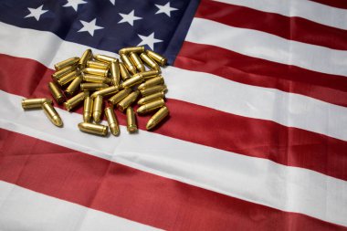 Amerikan bayrağında 9mm 'lik bir mühimmat grubuna yakın çekim. ABD 'de silah yasaları. silah mühimmatı.