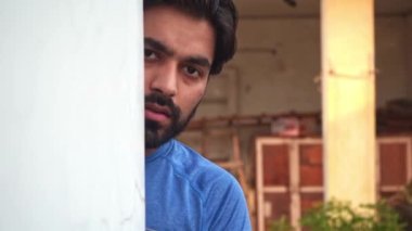 Hintli adam duvarın arkasında saklanıyor ve gözetliyor. Yaklaş.