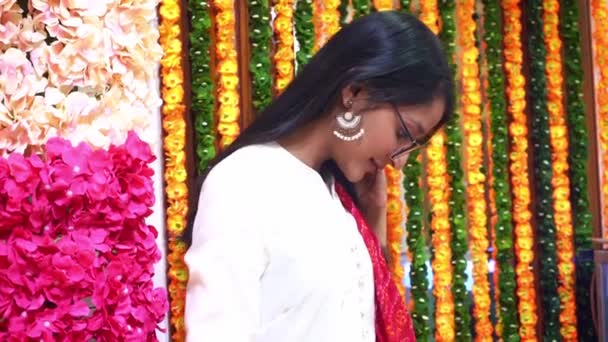 Side View Of Pretty Indian Girl Wears Eye Glasses And Big Earring With Colorful Garlands In Main Hindu Festival Diwali celebration In Agra, India - Medium Shot — стокове відео