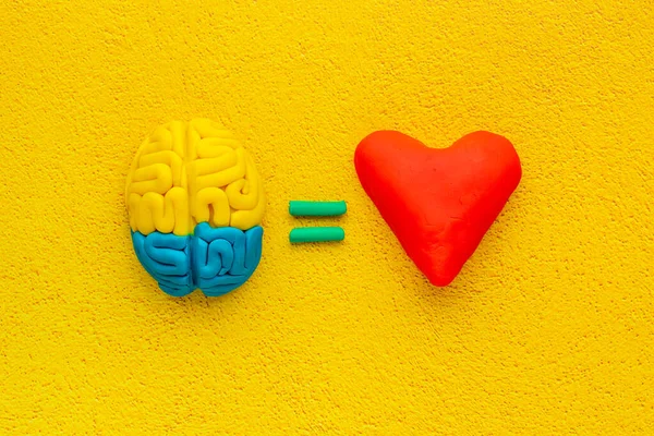 Emotional intelligence concept. Brain and heart made of clay, top view