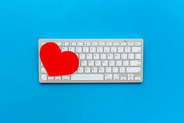Love emotion - online dating concept. Heart on the keyboard, top view