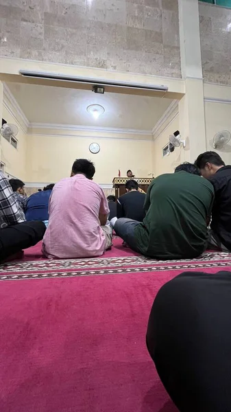 Camide yerde oturan insanlar.