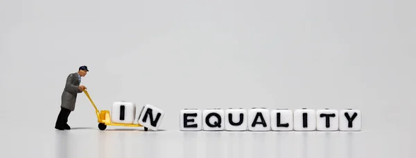 Koncepcja Równości Nierówności Miniaturowy Mężczyzna Niosący Białą Kostkę Wózku — Zdjęcie stockowe