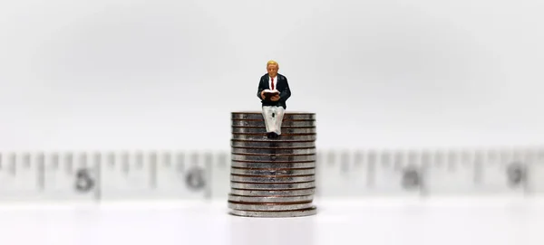 Hombre Miniatura Que Sienta Montón Monedas Delante Cinta Métrica Lee — Foto de Stock