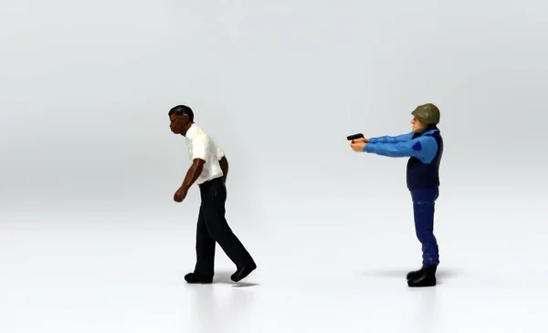 Uma Miniatura Policial Apontando Uma Arma Parte Trás Homem Miniatura — Fotografia de Stock