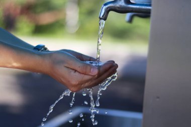 Su damlası musluk ve eller