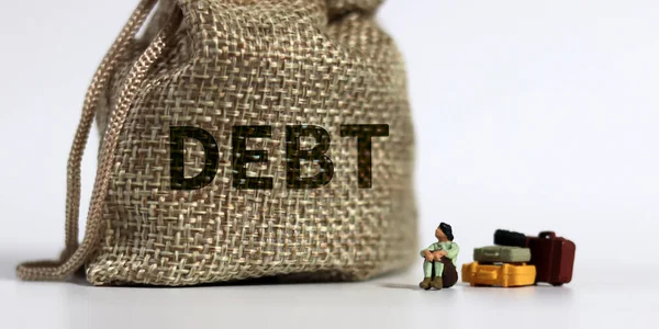 Debt という単語を持つバンドルとミニチュアの女性 過剰債務のリスクの概念 — ストック写真