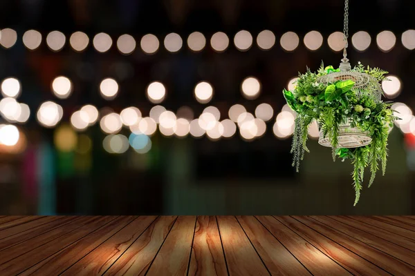 ブラーレストランの背景を持つトップデスクと木製の鳥ケージ 木製のテーブルと夜の通りの背景のぼんやりボケ — ストック写真