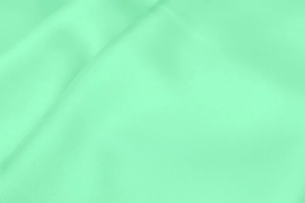 緑のサテン生地の質感柔らかいブラーの背景 — ストック写真