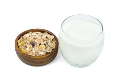 Şeffaf bardakta süt ve beyaz arka planda izole edilmiş ahşap kasede müsli multi meyvesi. 