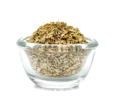 Kurumuş kekik yaprakları cam kasede, beyaz arka planda izole edilmiş.