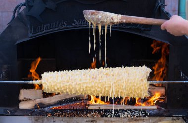 Sakotis 'i hazırlamak ya da pişirmek, Litvanya ve Polonya mutfağı geleneksel pasta katmanı kek ağacı pastası, pazarda ya da ateş ve alevlerle dolu bir Noel bisküvisi