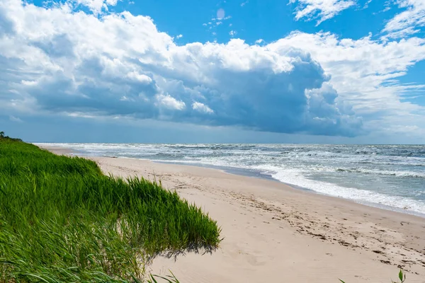 Surowe Morze Falami Zachmurzone Niebo Piaszczysta Plaża Wydmy Trzcinami Zieloną — Zdjęcie stockowe