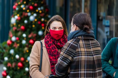 Vilnius, Litvanya - 11 Kasım 2020: Covid veya Coronavirus salgını sırasında maskeli ve toplantı yapan kızlar, Noel geçmişi