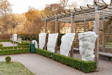 Parktaki bitki ve ağaçlar ya da bahçeler battaniye, çuval bezi, don koruma torbaları ya da kışın donmaktan ve soğuktan korunmak için kumaş ruloları ile kaplıdır.