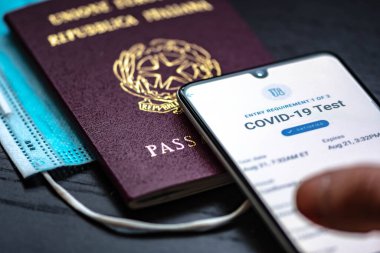 Roma, İtalya - 17 Ocak 2020: Aşı pasaport uygulaması pasaport ve maskeli bir akıllı telefon gösterdi 