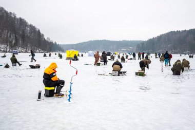 Balıkçılar kışın donmuş bir gölde olta ya da olta, buz çengeli ve balık tutmak için ekipmanla balık tutuyorlar.