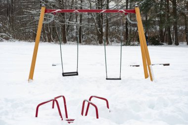 Çocuklar ve çocuklar oyun parkı ve aktiviteler için boş ve kışın kar yağarken karla kaplı.