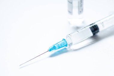 Üzerinde kapağı ya da kapağı olmayan bir şırınga, beyaz boş bir arkaplanda kullanılmaya hazır bir şişe ya da şişe. Covid veya Coronavirus aşısı veya monoklonal antikor arka planı, kapatın