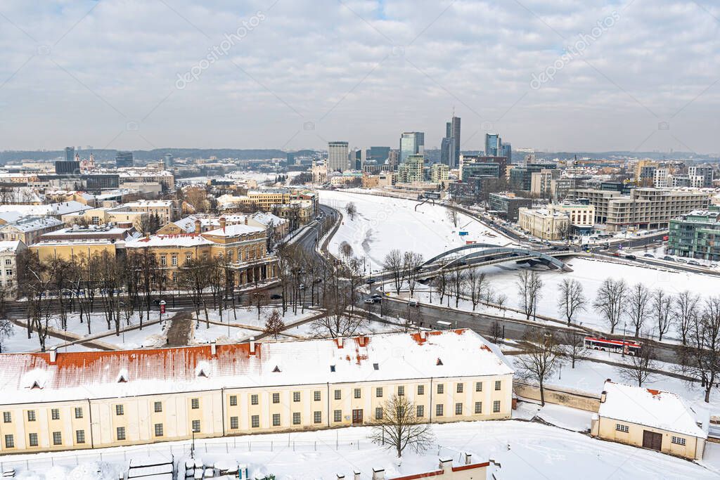 Vilnius, capital of Lithuania, beautiful scenic aerial panorama of modern business financial district architecture buildings with snow, Neris river and bridge 