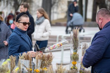 Vilnius, Litvanya - 28 Mart 2021 Palm ve Paskalya günü, çiçek pazarında güneş gözlüğü takan güzel bir kadın 