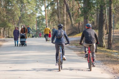 İlkbaharda şehirde bir parkta bisiklet ve kask takan sürücüler, sürdürülebilir ulaşım konsepti