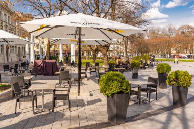 Vilnius, Litvanya - 21 Nisan 2021: Vilnius, Covid veya Coronavirus, masa, sandalye ve şemsiye gibi arka planda Katedral Kulesi nedeniyle barları ve restoranları yeniden açıyor