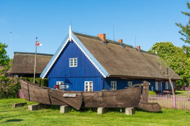 Nida, Litvanya - 23 Mayıs 2021 Balıkçı Müzesi. Litvanya 'nın geleneksel ahşap evleri sazdan çatılı ve Litvanya' nın Nida balıkçı köyündeki Curonian Spit 'in eski teknesi