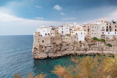 Karabasan Polignano. Kayalıklardaki kasaba, Puglia bölgesi, İtalya, Avrupa. Eski geleneksel evler, dramatik gökyüzü ve Akdeniz ile seyahat konsepti