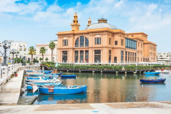 Arka planda ahşap renkli tekneleri ve tiyatrosu olan küçük liman, Bari, Puglia, İtalya
