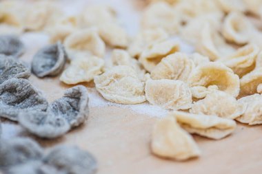 Güney İtalya 'nın bir bölgesi olan Puglia veya Apulia' nın tipik el yapımı makarnası, buğday ve suyla yapılan taze orekchiette veya orekchietta, yakın plan.