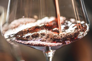 Kırmızı şarabı köpüklü bir şarap bardağına boşalt.