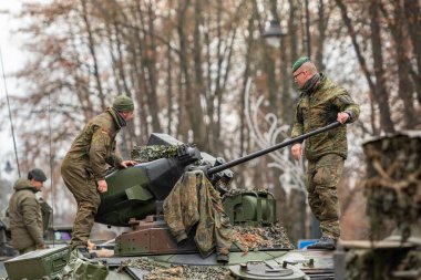 Vilnius, Litvanya - 22 Kasım 2025: Alman askerleri zırhlı bir Alman tankının taretinde yürüyen ve gökyüzünü gösteren bir otomatik top ile