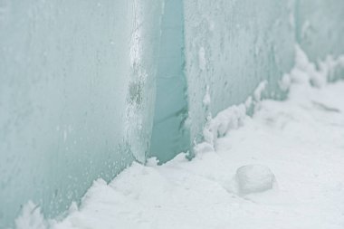 Taze beyaz kar üzerinde dinlenen şeffaf buz bloklarının yer aldığı soyut kış sahnesi, donmuş dokular, serin tonlamalar ve soğuk açık havada minimalist doğal formlar sergiliyor.