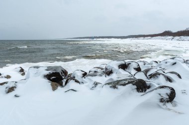 Donmuş dalgalarla dondurucu kış deniz manzarası, Litvanya 'nın Palanga kentindeki Baltık Denizi' nde karlı bir kıyı şeridi boyunca yüzen buzlar.