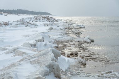 Donmuş dalgalarla dondurucu kış deniz manzarası, Litvanya 'nın Palanga kentindeki Baltık Denizi' nde karlı bir kıyı şeridi boyunca yüzen buzlar.
