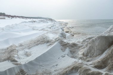 Donmuş dalgalarla dondurucu kış deniz manzarası, Litvanya 'nın Palanga kentindeki Baltık Denizi' nde karlı bir kıyı şeridi boyunca yüzen buzlar.
