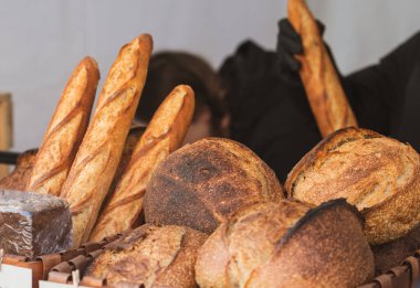 Fırında ya da sokak gıda pazarında hasır sepetlerde sergilenen taze pişmiş çeşitli ekmek türleri